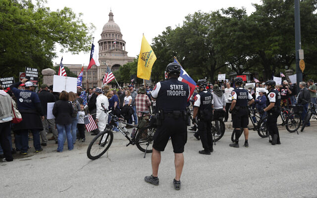 State troopers keep watch as protesters rally at the Texas State Capitol to speak out against Texas' handling of the COVID-19 outbreak, in Austin, Texas, Saturday, April 18, 2020. (AP/Eric Gay)