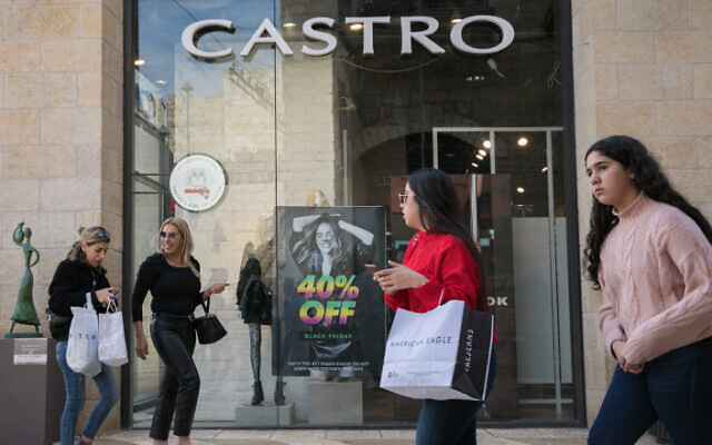 File: People walk past black friday advertisements at an outlet of the "Castro" fashion chain in Jerusalem, November 24, 2019 (Olivier Fitoussi/Flash90)