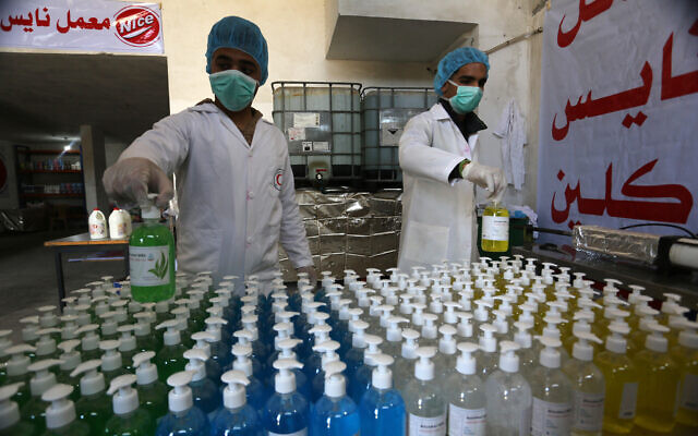 Palestinian workers making hand sanitizer at a factory in Khan Younis, in the southern Gaza Strip, on March 16, 2020 (Abed Rahim Khatib/ Flash90)