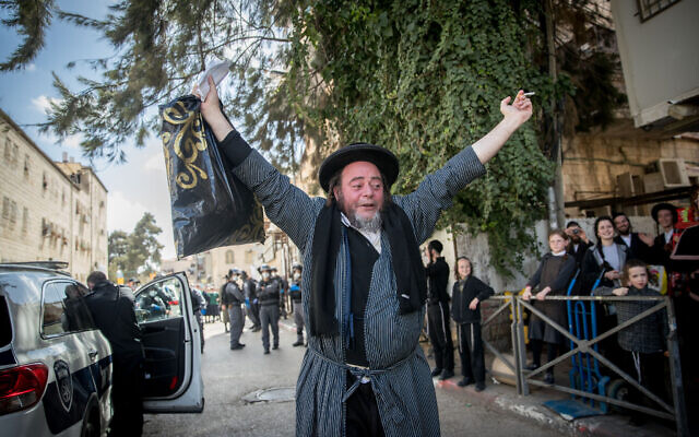 Police officers close synagogues and hand out fines to Haredi Jews in the Mea Shearim neighborhood of Jerusalem, following government restrictions imposed as part of the effort to contain the spread of the coronavirus, April 6, 2020. (Yonatan Sindel/Flash90)
