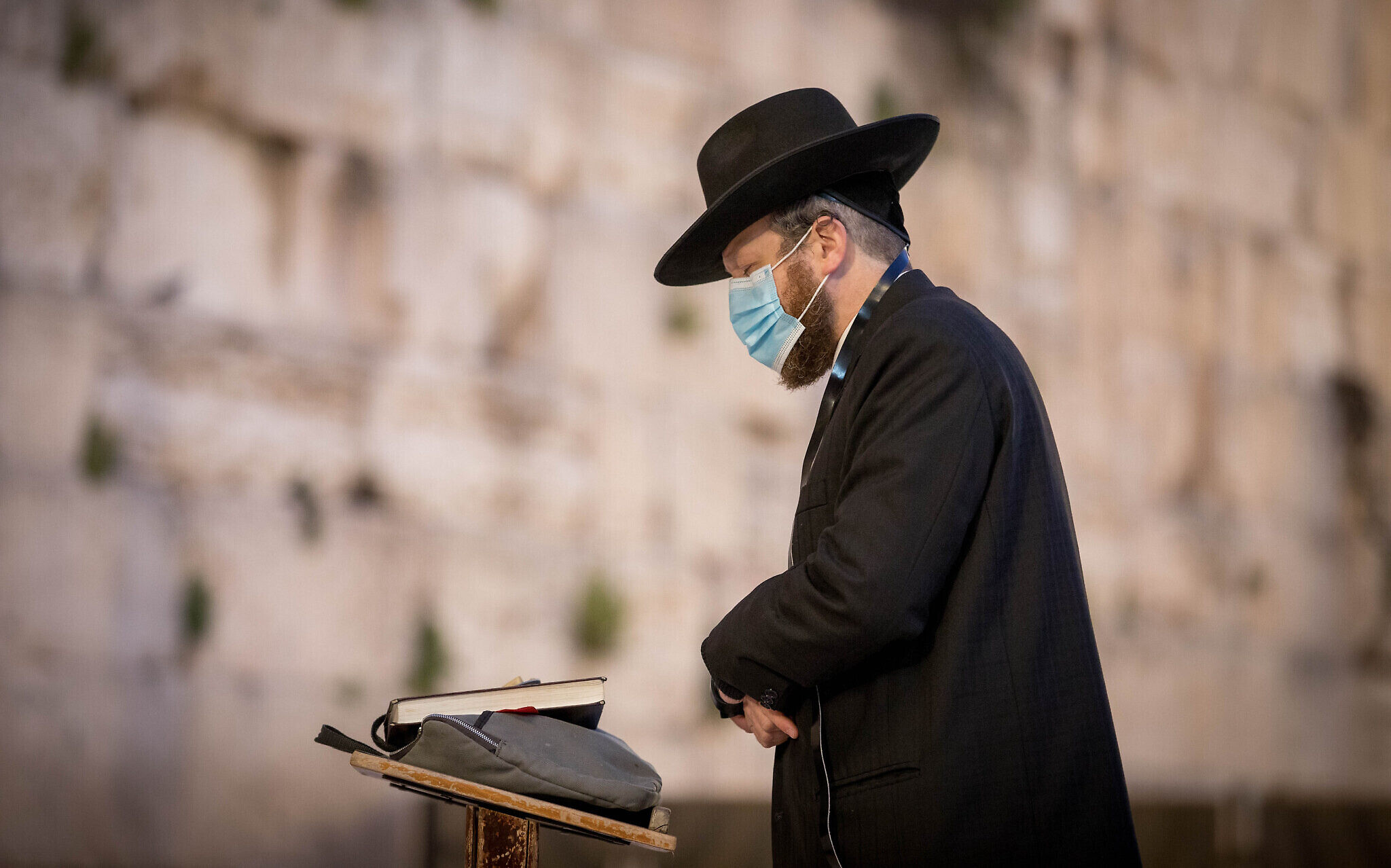 A Haredi man prays at the almost empty Western Wall, Judaism's holiest prayer site, in the Old City of Jerusalem, April 7, 2020. (Nati Shohat/Flash90)