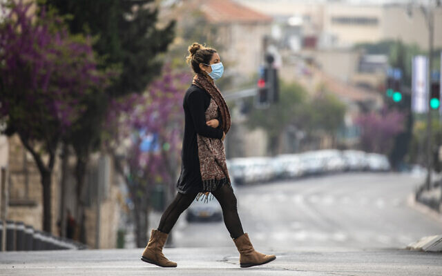 An Israeli woman with a face mask walks in Jerusalem on April 15, 2020. (Olivier Fitoussi/Flash90)