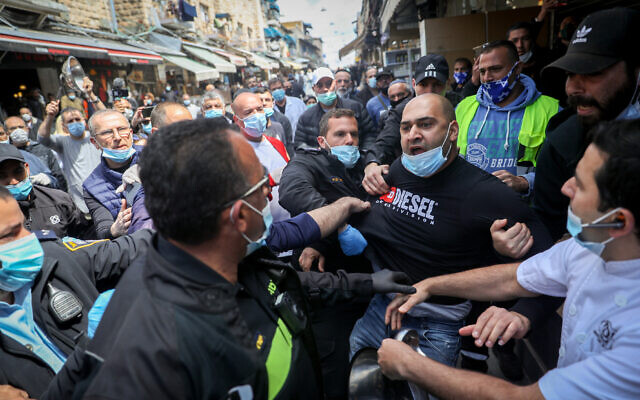 Store owners at Jerusalem's Mahane Yehuda market scuffle with police during a protest over the continued closure of open-air markets, April 25, 2020. (Yonatan Sindel/Flash90)