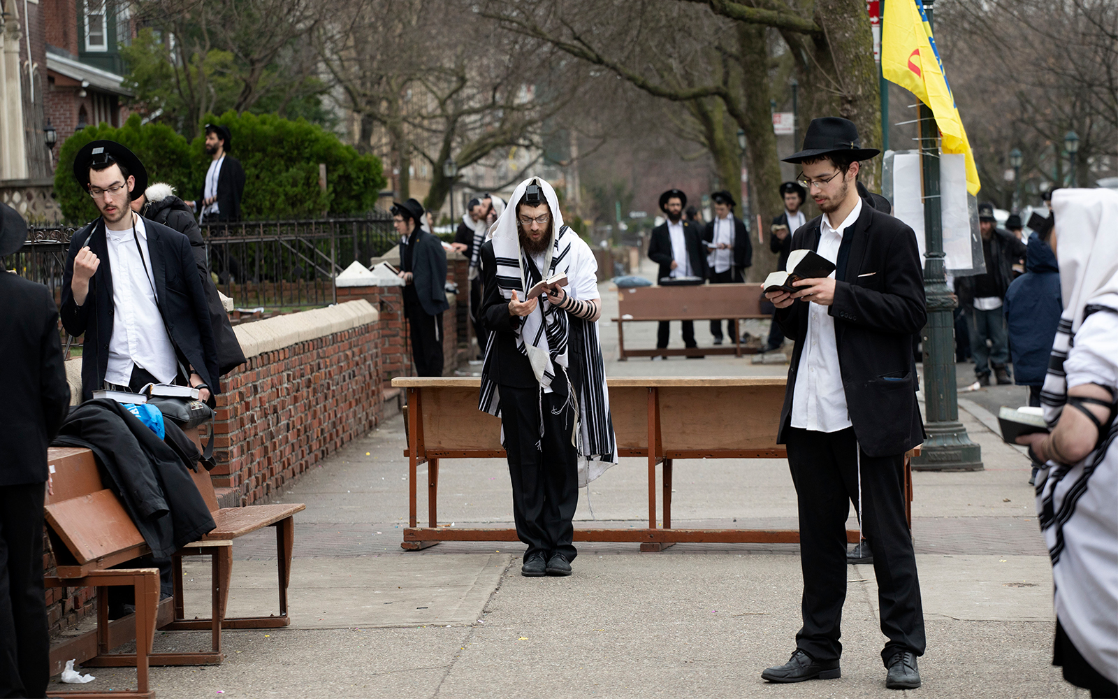 Ultra-Orthodox Jewish men use social distancing as they pray outside the Chabad Lubavitch World Headquarters, in Brooklyn, New York, March 20, 2020. (AP/Mark Lennihan)