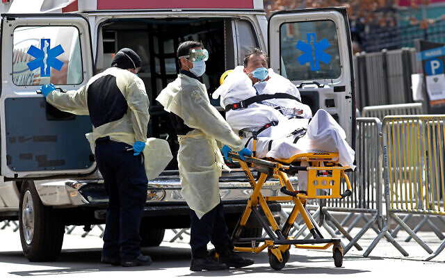 A patient is wheeled out of Elmhurst Hospital Center to a waiting ambulance, in the Queens borough of New York, April 7, 2020. (AP/Kathy Willens)