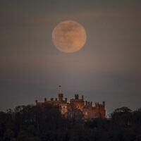 A supermoon is seen over Belvoir castle in Leicestershire, England, Tuesday, April 7, 2020. (Danny Lawson/PA via AP)