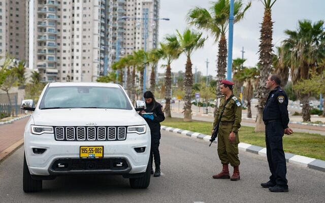 An IDF officer helps police run a checkpoint during the coronavirus outbreak on April 2, 2020. (Israel Defense Forces)