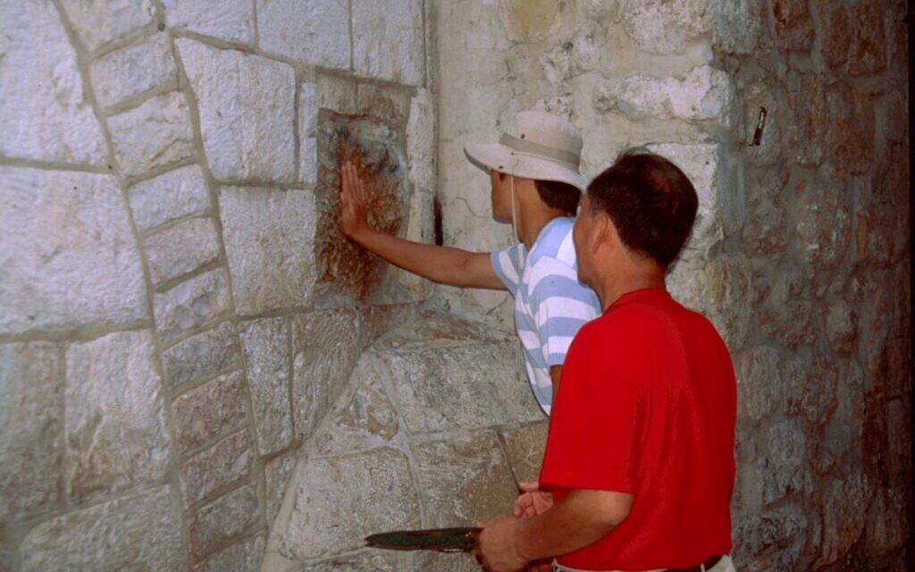 Christian pilgrims at the Via Dolorosa's fifth station, where Christian tradition holds Jesus rested a palm in order to gain a small moment of respite. (Shmuel Bar-Am)