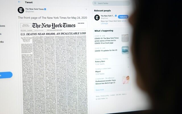 This picture from May 23, 2020, shows a woman looking at a computer screen with a tweet by the New York Times account showing the early edition front page of the newspaper for May 24, 2020 (Agustin Paullier/AFP)