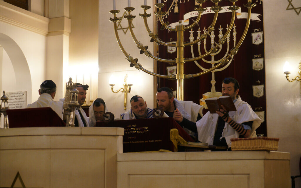 Rabbi Michael Azoulay, second from right, reading the Torah with congregants at the synagogue of Neuilly-sur-Seine, a Paris suburb, Dec. 11, 2017. (Cnaan Liphshiz/JTA)