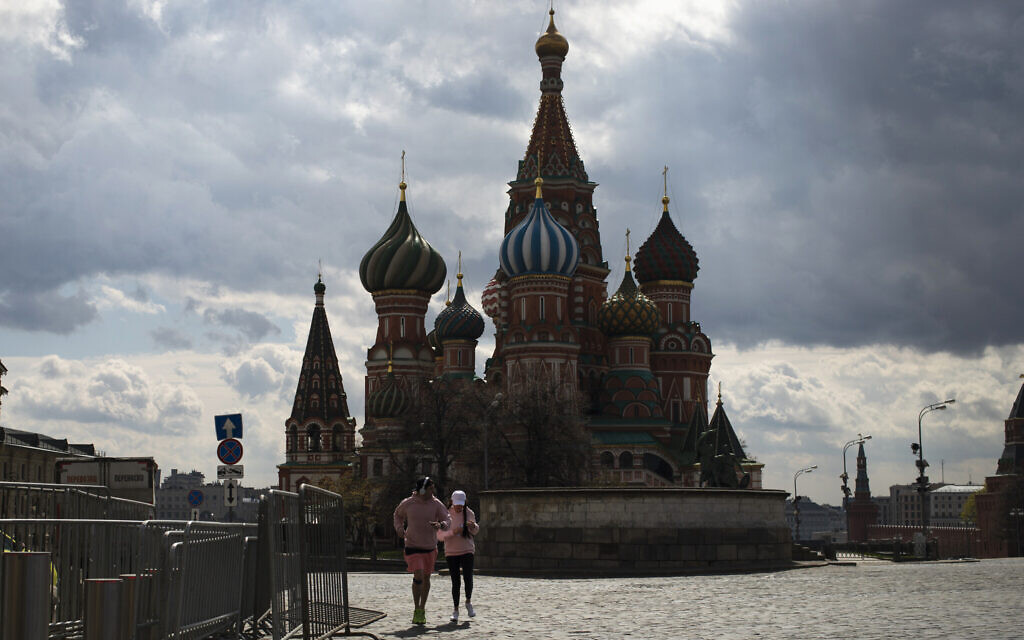 A couple run in an empty Red Square, with St. Basil's Cathedral in the background, during a self-isolation regime due to coronavirus in Moscow, Russia, April 29, 2020. Russian President Vladimir Putin has extended the nation's partial economic shutdown through May 11, saying the coronavirus outbreak is yet to reach a peak. (AP Photo/Pavel Golovkin)