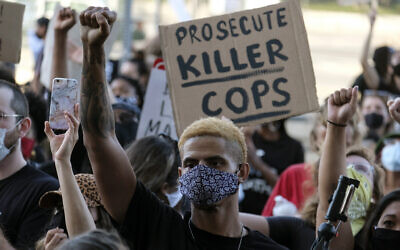 A demonstrator raises his fist during a protest of the death of George Floyd, a black man who died in police custody in Minneapolis, in downtown Los Angeles, May 27, 2020. (Ringo H.W. Chiu/AP)