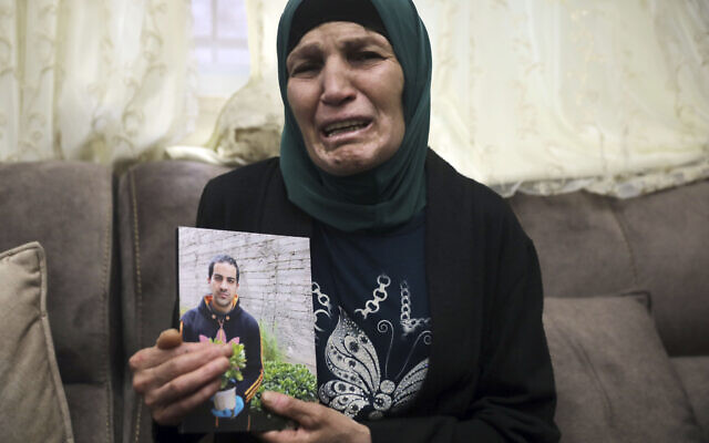 Rana, mother of Iyad Halak, 32, holds his photo at their home in East Jerusalem's Wadi Joz, May 30, 2020 (AP Photo/Mahmoud Illean)
