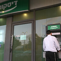 A man stands at a cash machine of the Israel Discount Bank in Jerusalem, on July 1, 2013. (Nati Shohat/Flash 90)