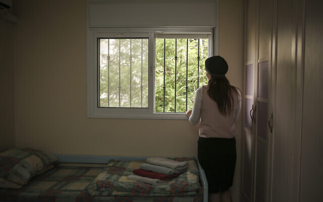 Illustrative: A woman looks out the window of her room in an abused women's shelter in Beit Shemesh, July 15, 2014. (Hadas Parush/Flash90)
