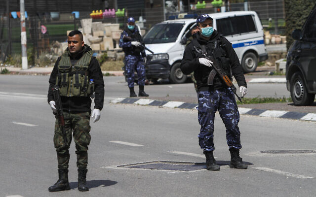 Palestinian security forces guard at the entrance to the West Bank city of Nablus on March 23, 2020, as part of measures to contain the coronavirus. (Nasser Ishtayeh/Flash90)