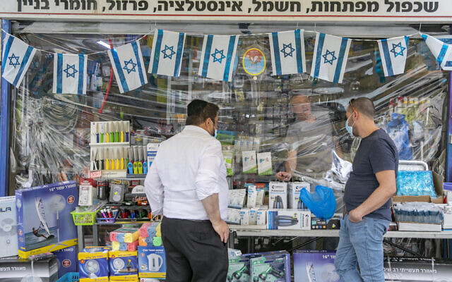 Israelis wearing face masks for fear of coronavirus do their shopping in Jerusalem City center after the government eased some lockdown measures on May 03, 2020. (Olivier Fitoussi/Flash90)