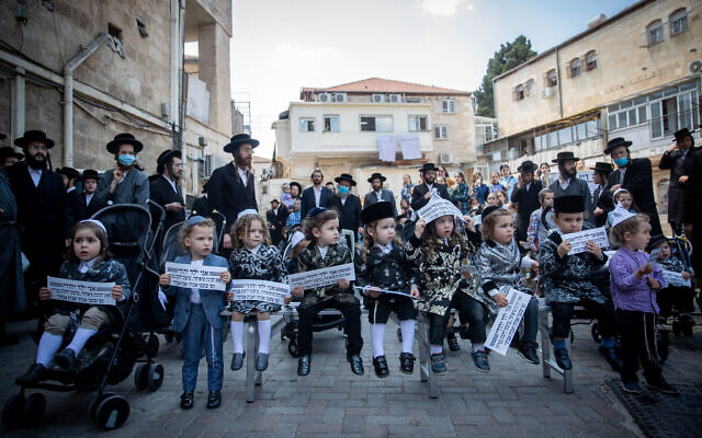 Ultra-Orthodox men and their children protest the government restrictions that prevent them from reaching Mount Meron on Lag B’Omer, in the Jerusalem neighborhood of Mea Shearim on May 10, 2020. (Yonatan Sindel/Flash90)
