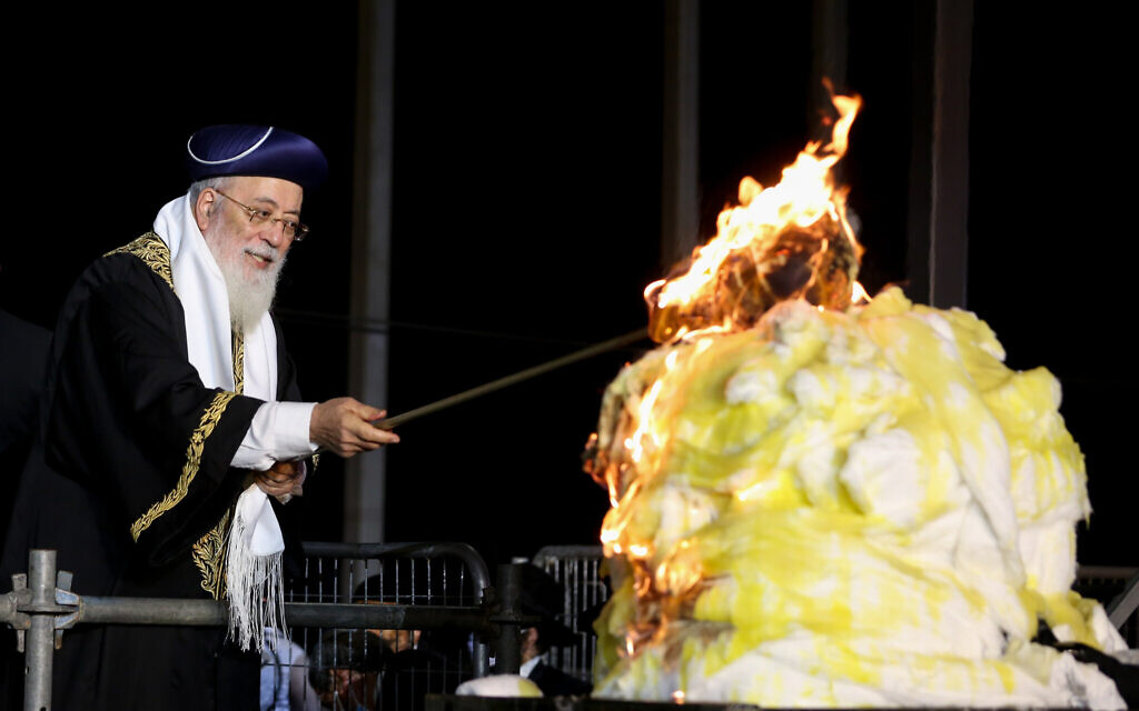 Sephardic Chief Rabbi of Jerusalem Rabbi Shlomo Amar lights a bonfire during the celebrations of the Jewish holiday of Lag B'Omer at Mount Meron in northern Israel on May 11, 2020. (David Cohen/Flash90)