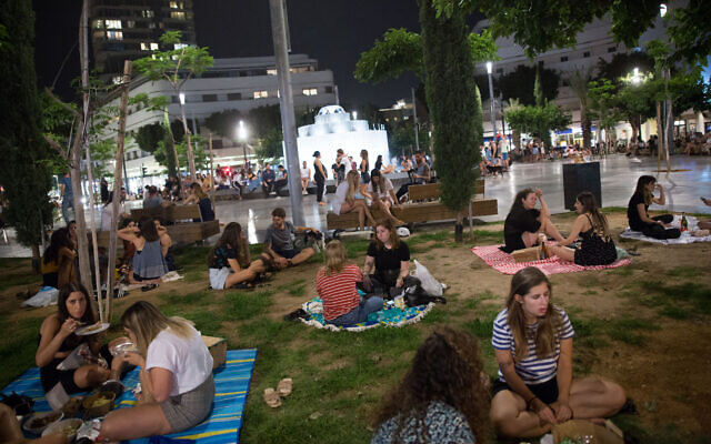 Israelis have picnics at Tel Aviv's Dizengoff Square as restaurants, cafes and bars remain closed except for take out and deliveries, May 20, 2020. (Miriam Alster/Flash90)