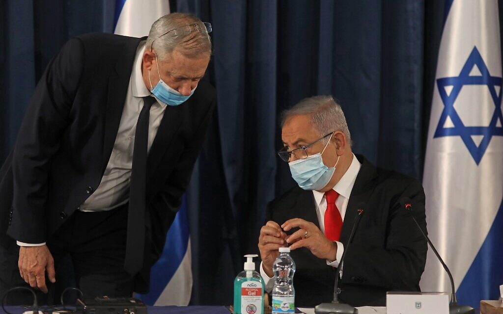 Prime Minister Benjamin Netanyahu (R) speaks with Alternate PM and Defense Minister Benny Gantz, both wearing protective mask due to the ongoing COVID-19 pandemic, during the weekly cabinet meeting in Jerusalem on June 7, 2020. (Menahem KAHANA / AFP)