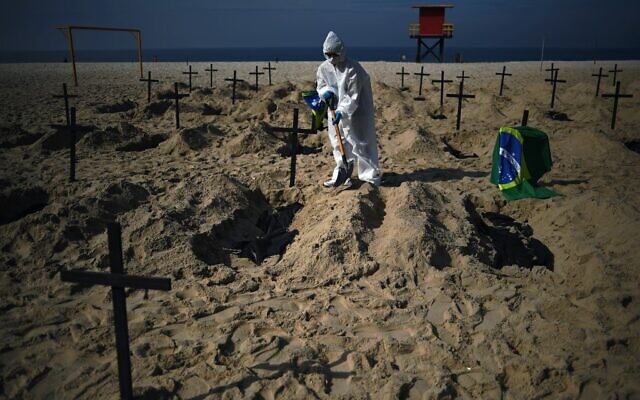 Activists from the Brazilian NGO Rio de Paz (Peace Rio), dig 100 mock graves on Copacabana beach symbolizing deaths from the COVID-19 coronavirus in Rio de Janeiro, Brazil, on June 11, 2020, to protest against Brazil's "bad governance" of the pandemic. (CARL DE SOUZA / AFP)