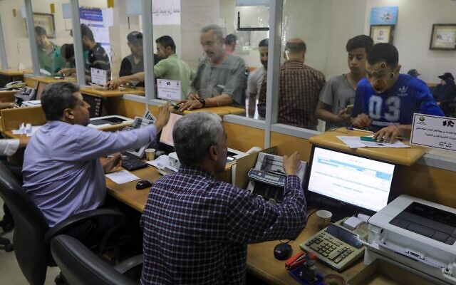 Palestinians receive financial aid payments from Qatar at a post office in Gaza City, on June 27, 2020. (Mahmud Hams/AFP)