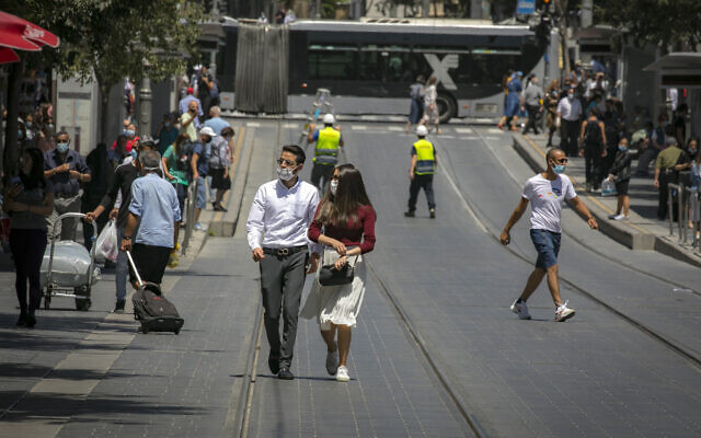People wearing face masks walk in Jerusalem on June 24, 2020. (Olivier Fitoussi/Flash90)