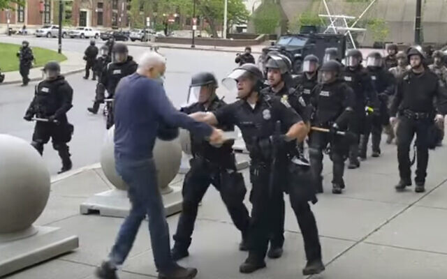 In this image from video provided by WBFO, a Buffalo police officer appears to shove a man who walked up to police Thursday, June 4, 2020, in Buffalo, N.Y. Video from WBFO shows the man appearing to hit his head on the pavement, with blood leaking out as officers walk past to clear Niagara Square. (Mike Desmond/WBFO via AP)