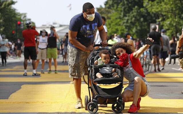 Katie Williams, right, poses for a photo with her son Benjamin, 18 months, and husband Kyle near the White House on June 6, 2020, in Washington, as people gather before scheduled protests over the death of George Floyd, who died after being restrained by Minneapolis police officers. (AP/Patrick Semansky)