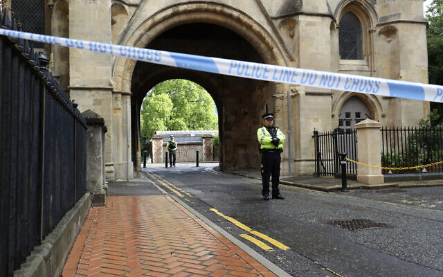 Police stand guard at the Abbey gateway of Forbury Gardens park in Reading town center following Saturday's stabbing attack in the gardens, June 21, 2020. (Jonathan Brady/PA via AP)