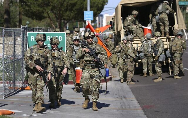 Arizona National Guard troops disembark from military vehicles near the Arizona Capitol on Tuesday, June 2, 2020, in Phoenix, where there have been several days of protests over the death of George Floyd, who died May 25 after being restrained by Minneapolis police. (AP Photo/Ross D. Franklin)