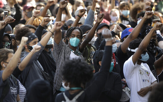 Demonstrators raise their arms during a protest against police brutality,  in Boston, June 10, 2020. (Steven Senne/AP)