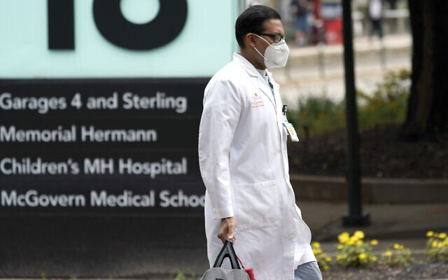 A healthcare professional walks through the Texas Medical Center on June 25, 2020, in Houston. (AP Photo/David J. Phillip)