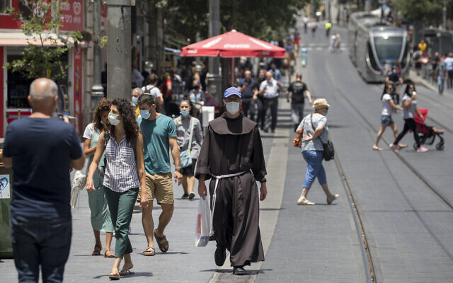 People wearing face masks walk in Jerusalem on June 8, 2020. (Olivier Fitoussi/ Flash90)