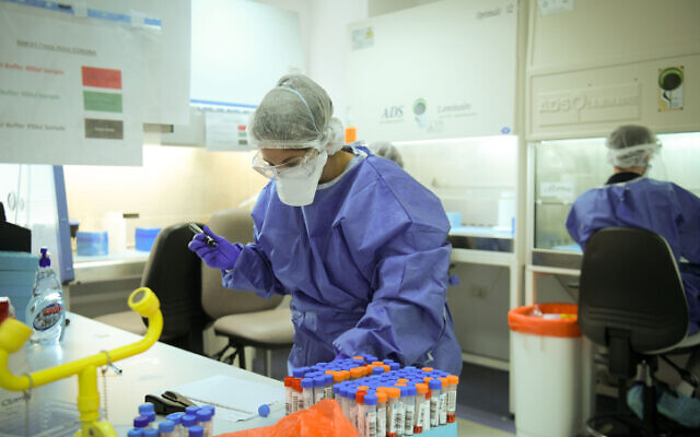 Technicians carry out a diagnostic test for coronavirus in a lab in Tel Aviv, on June 9, 2020 (Yossi Zeliger/Flash90)