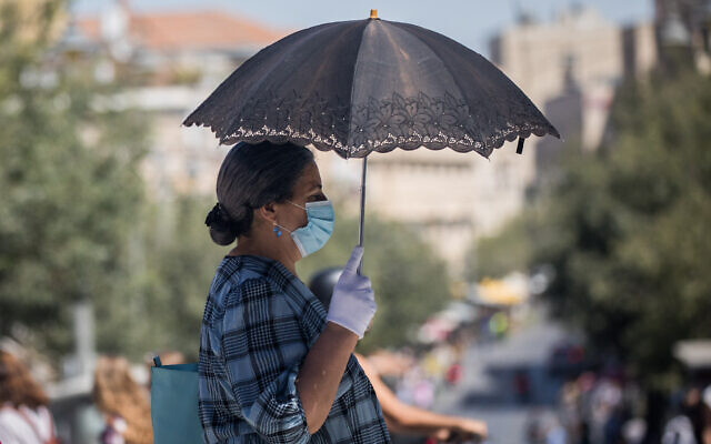 People walk with face masks on Jaffa Street in downtown Jerusalem on June 24, 2020. (Yonatan Sindel/Flash90)