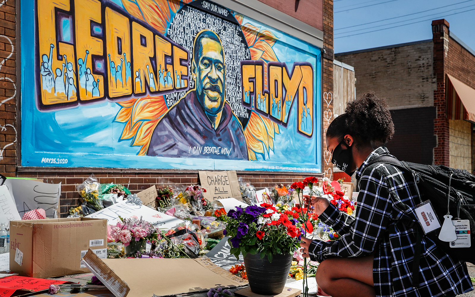 Malaysia Hammond, 19, places flowers at a memorial mural for George Floyd at the corner of Chicago Avenue and 38th Street, May 31, 2020, in Minneapolis. (AP/John Minchillo)
