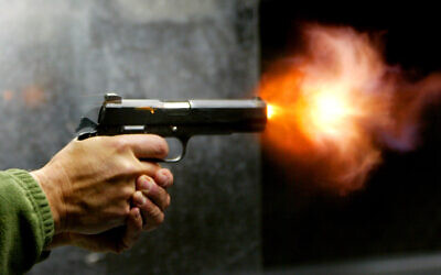 Illustrative. An Israeli man fires a pistol at a shooting range in Jerusalem on March 8, 2007. (Olivier Fitoussi/Flash90)