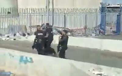 Palestinian man is detained at the Qalandiya checkpoint after he was found to be carrying a knife, June 27, 2020 (Screen capture/Kan)