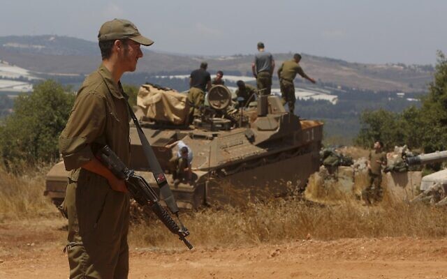 An Israeli soldier stands near a Namer Infantry Fighting Vehicle near the town of Avivim in northern Israel along the border with Lebanon on July 23, 2020. (JALAA MAREY / AFP)