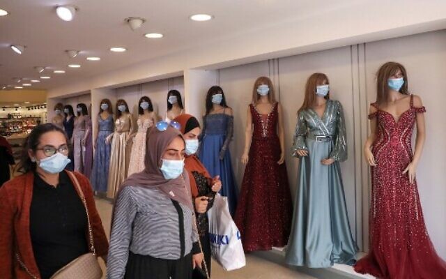 Palestinian women wearing protective masks amid the COVID-19 pandemic, shop at a clothing store as Muslims prepare for the Eid al-Adha feast, in the West Bank city of Hebron, on July 27, 2020. (HAZEM BADER / AFP)