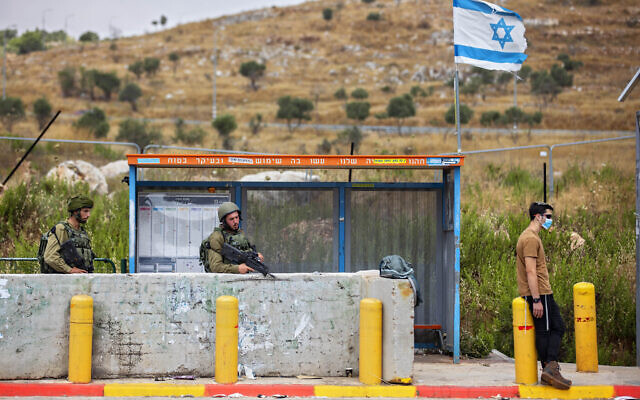 IDF soldiers guard a bus station at the Tapuah junction next to the West Bank city of Nablus, Tuesday, June 30, 2020. (AP/Oded Balilty)