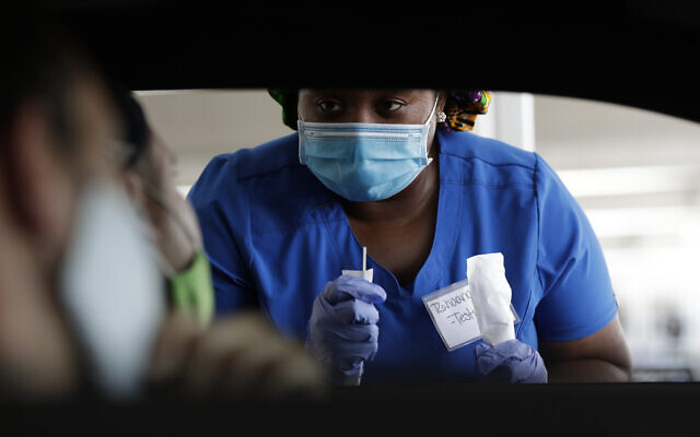 Healthcare worker Rahaana Smith instructs passengers how to use a nasal swab, on Friday, July 24, 2020, at a drive-thru coronavirus testing site in Miami. (AP/Wilfredo Lee)