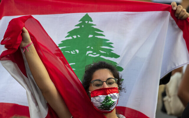 An anti-government protester shouts slogans while wearing a mask with the colors of the Lebanese flag in Beirut, Lebanon, on July 2, 2020. (Hassan Ammar/AP)