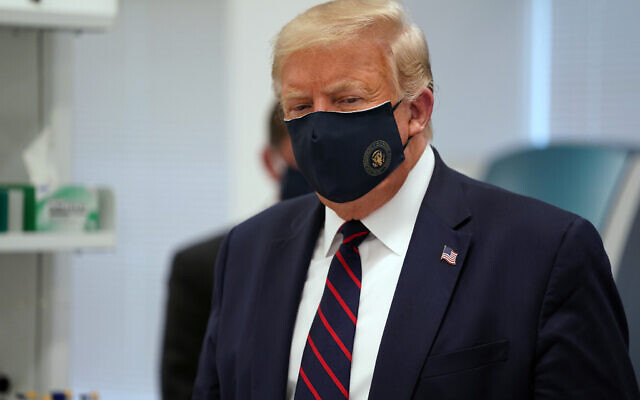 US President Donald Trump wears a face mask as he participates in a tour of Bioprocess Innovation Center at Fujifilm Diosynth Biotechnologies, Monday, July 27, 2020, in Morrisville, N.C. (AP Photo/Evan Vucci)