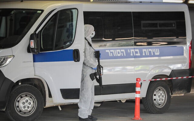 Prison guards wearing protective clothing as a preventive measure against the coronavirus, seen as they transport a prisoner suspected of having the coronavirus at Shaare Zedek Medical Center in Jerusalem on March 30, 2020. (Yossi Zamir/Flash90)