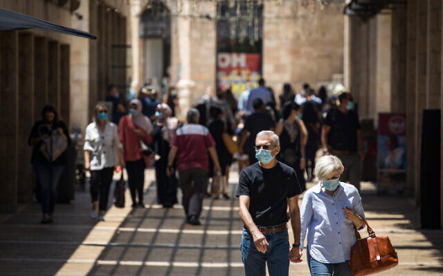 Illustrative: People wearing face masks walk and shop at the Mamilla mall near Jerusalem's Old City on July 6, 2020 (Olivier Fitoussi/Flash90)