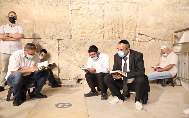 Jewish men pray at the Western Wall on the eve of Tisha B'Av in the Old City of Jerusalem, on July 29, 2020. (Olivier Fitoussi/Flash90)