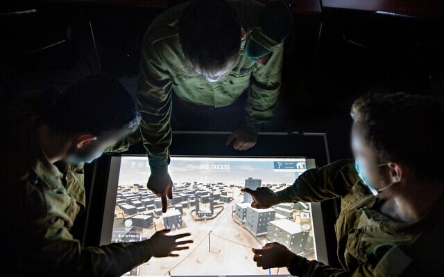 Illustrative. Soldiers from the Military Intelligence Unit 9900, which specializes in visual intelligence, use a map of a military base in southern Israel in an undated photograph. (Israel Defense Forces)